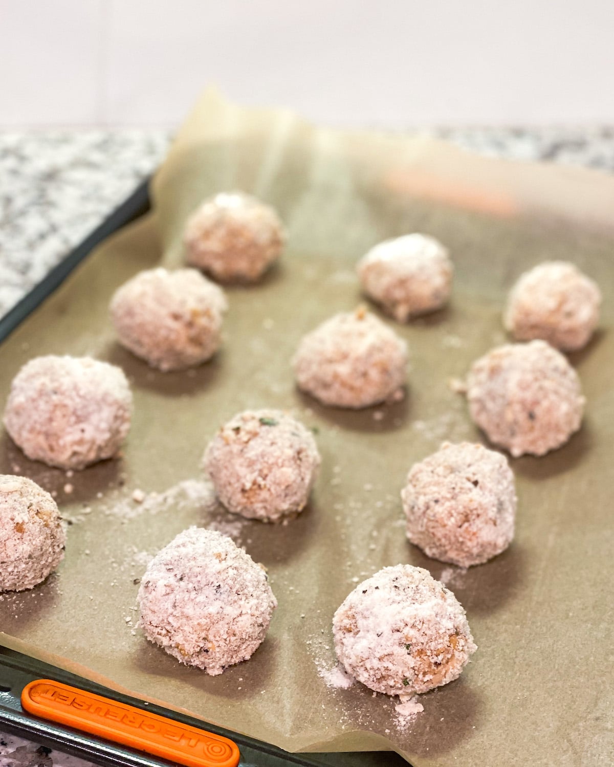 12 cauliflower Rice Balls prepped on a baking sheet