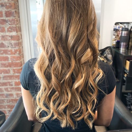 back of woman's head curled brunette hair with blonde highlights
