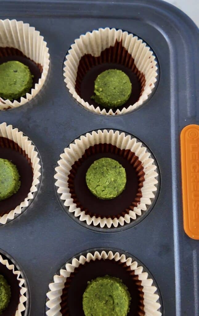 Adding the mint matcha filling to the muffin tin.